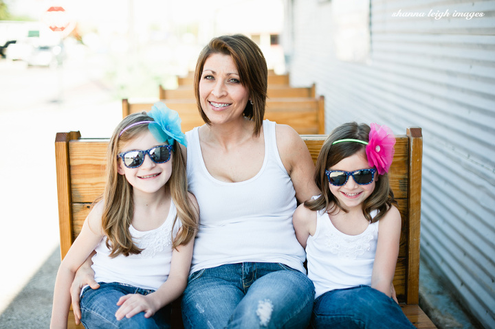 A mother and her daughters in white tank tops, jeans, and bright colored flower headbands with mirrored sunglasses in Grapevine, Texas.