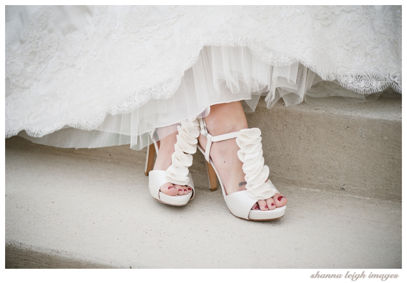 Jennifer showing off her ruffled shoes for her bridal portraits at her gorgeous mediterranean style wedding venue, the Piazza in the Village in Colleyville, Texas.