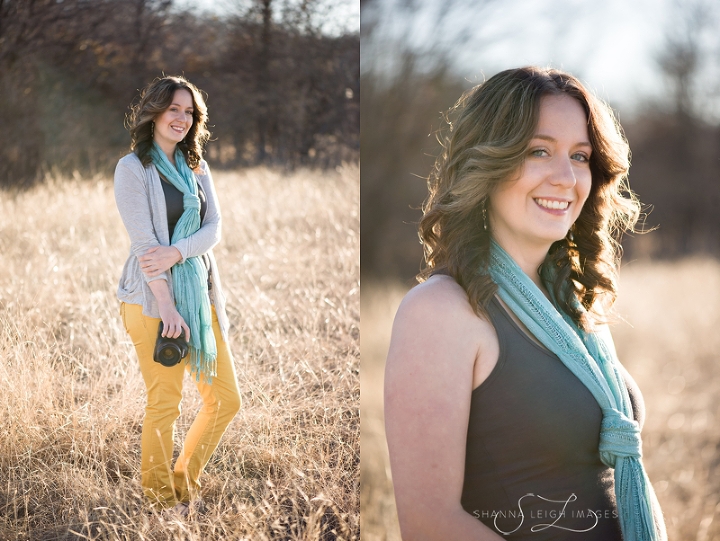 A photographer posing with her Canon camera with mustard colored jeans and an aqua scarf in an overgrown field.