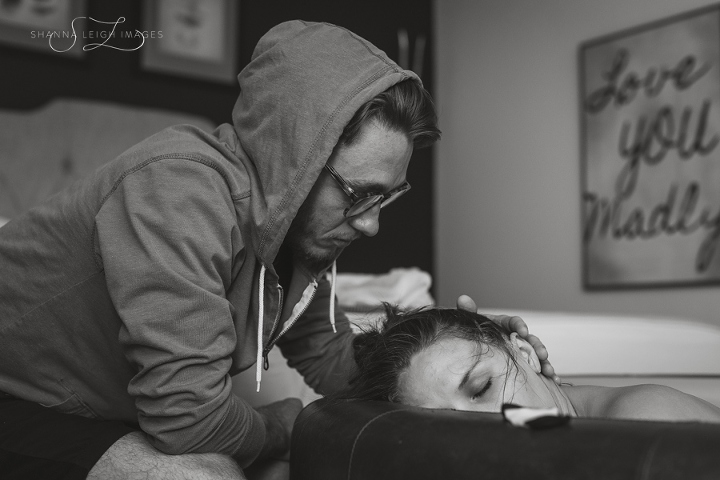 An expectant father supports his partner in labor for her water birth at Gentle Beginnings Birth Center in Hurst, Texas.