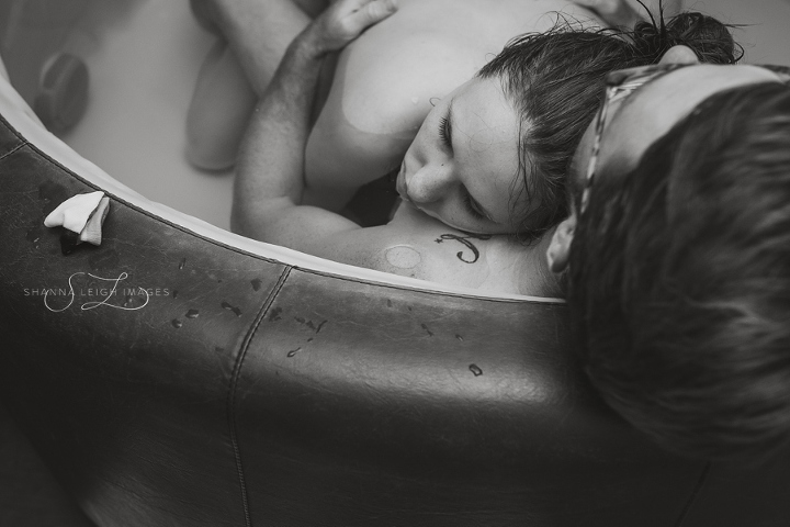 An expectant father supports his partner in labor for her water birth at Gentle Beginnings Birth Center in Hurst, Texas.