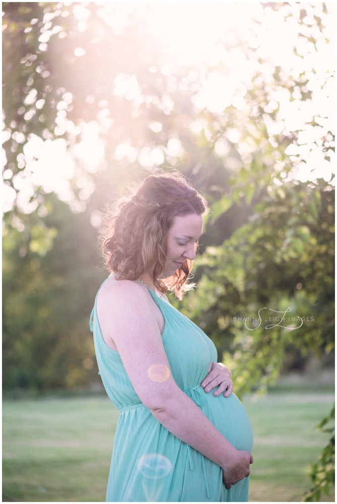 A beautiful pregnant woman in a light blue flow maternity dress poses for her maternity photos in Fort Worth, TX at sunrise.