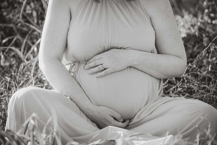 A beautiful pregnant woman in a light blue flow maternity dress poses for her maternity photos in Fort Worth, TX at sunrise.