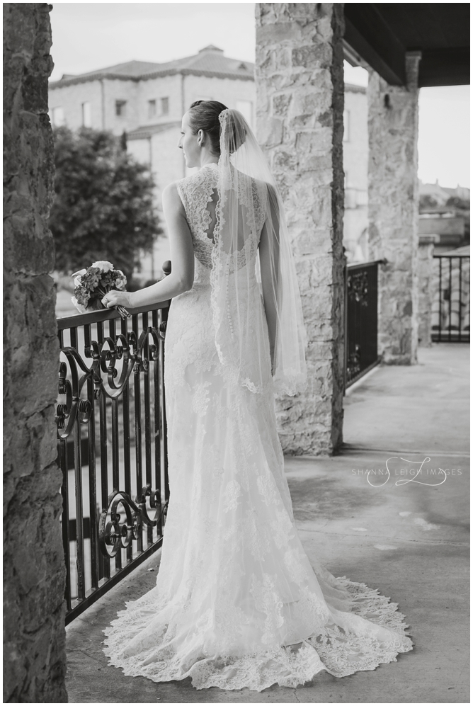 Stephanie in her lace Allure bridal gown posing for her bridal portraits at Adriatica in McKinney, Texas.