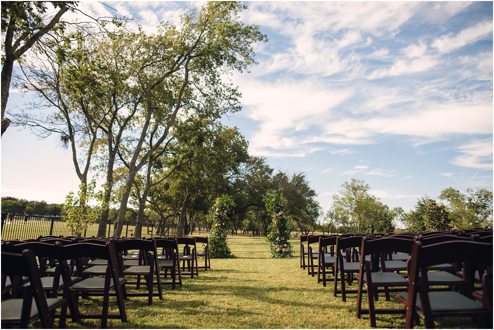 Wooden chairs set up on the lawn for an intimate wedding.