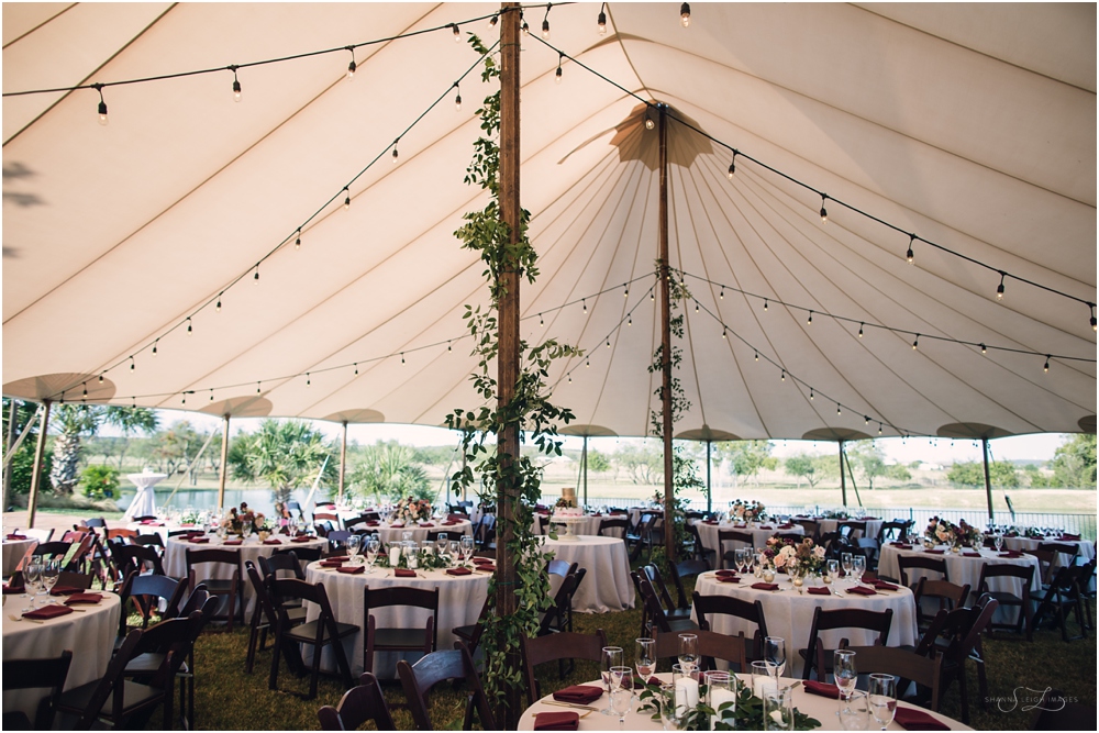 A beautiful fall wedding reception under a big white pennant tent.